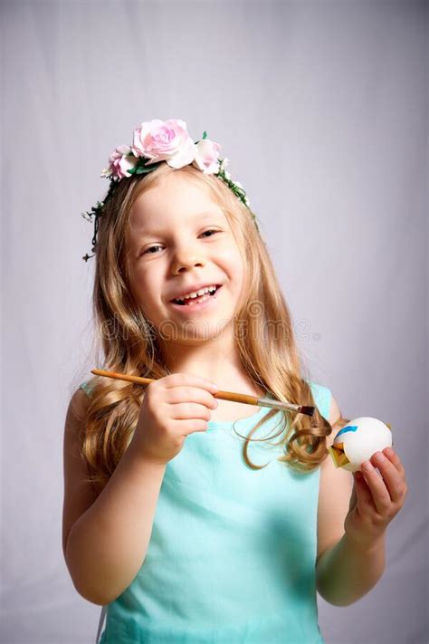 Pretty Blonde Little Girl Painting Easter Eggs On White Background