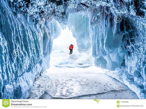Winter Landscape Frozen Ice Cave With Young Photographer Standing