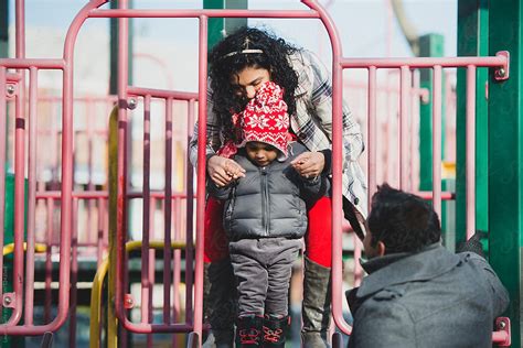 Mom Helping Child At Playground By Stocksy Contributor Lauren Lee