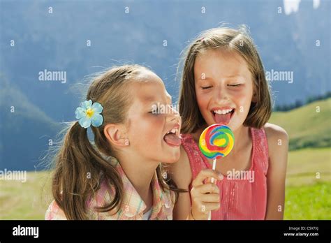 Italy South Tyrol Two Girls 6 7 10 11 Licking Lollypop Stock
