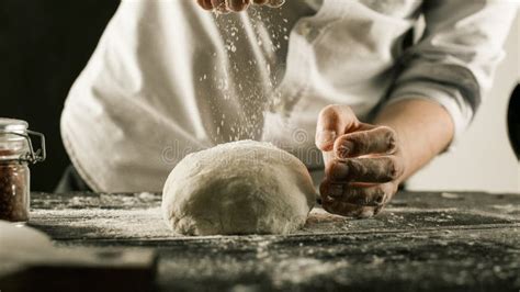 Male Chef Hands Knead Dough With Flour On Kitchen Table Stock Photo