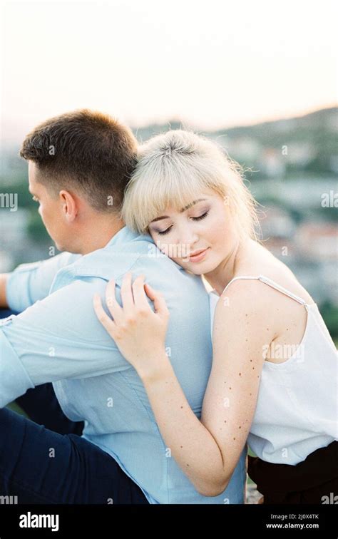 Woman Hugs A Man From Behind With Her Head On His Shoulder Portrait