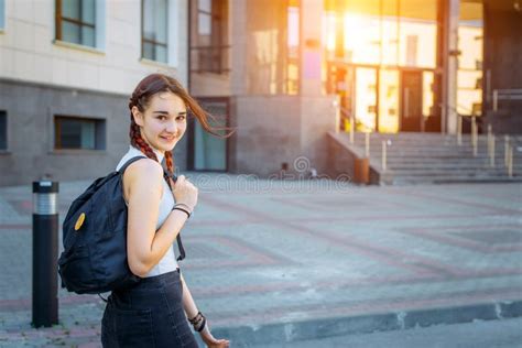 A High School Student With A Backpack Stands On The University Yard