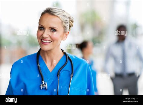 Beautiful Medical Nurse With Colleagues On Background Stock Photo Alamy