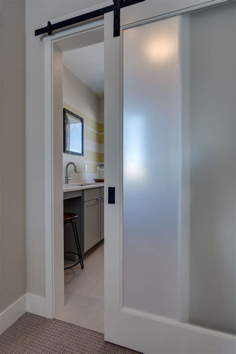 an etched glass barn door greets you as you enter the spacious upper level laundry room glass
