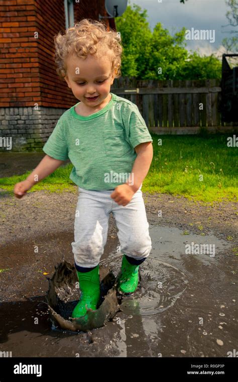 Boy Playing In Puddle Stock Photo Alamy