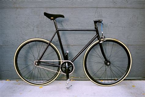 A Black And Gold Bicycle Leaning Against A Wall