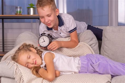 Premium Photo Brother Wakes Up Sister With Alarm Clock Calls Loudly