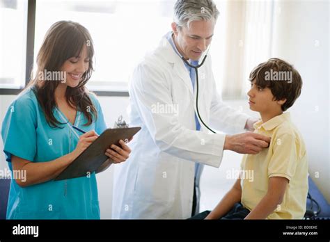 Male Doctor And Female Nurse Helping Boy Stock Photo Alamy