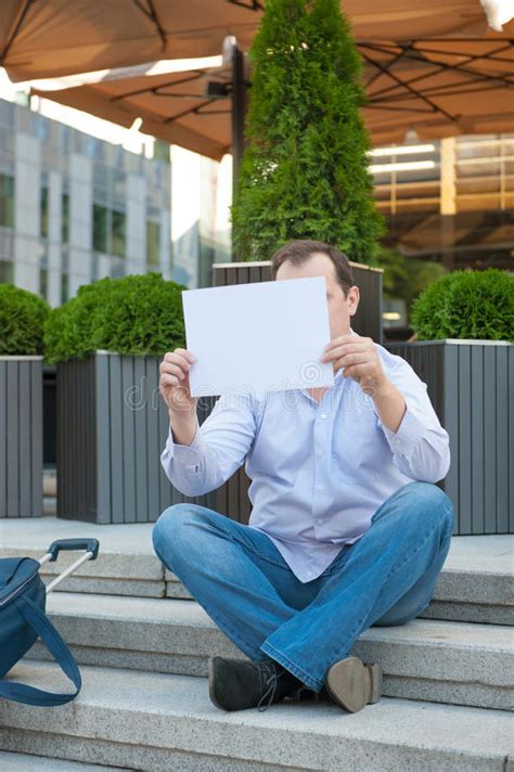 Sad Man Sitting On The Steps With A Suitcase Empty Sign Stock Photo