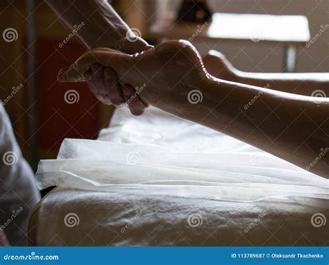 Professional Masseur Doing Kneads Legs Of A Girl At Ayurveda Oiled Massage Session Stock Image