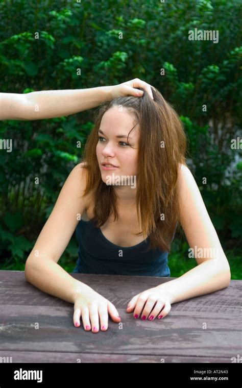 Teen Girl Sitting At A Picnic Table Her Younger Sister S Hand Resting