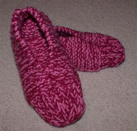 A Pair Of Pink Knitted Slippers Laying On The Floor
