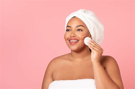 skincare routine happy black chubby woman cleansing skin with cotton pad removing makeup from