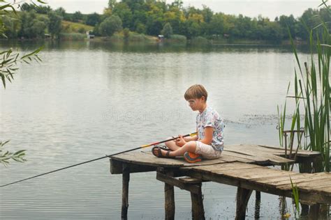 Boy Sitting And Fishing From A Dock Stock Photo Image Of River Fish