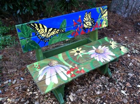 A Painted Wooden Bench Sitting In The Middle Of Some Leaves And Grass