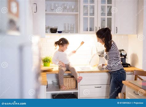 Mother With Her Daughter In The Kitchen Cooking Together Stock Image Image Of Casual Holding