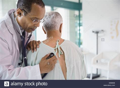 Male Doctor Checking Senior Patient With Stethoscope Stock Photo Alamy