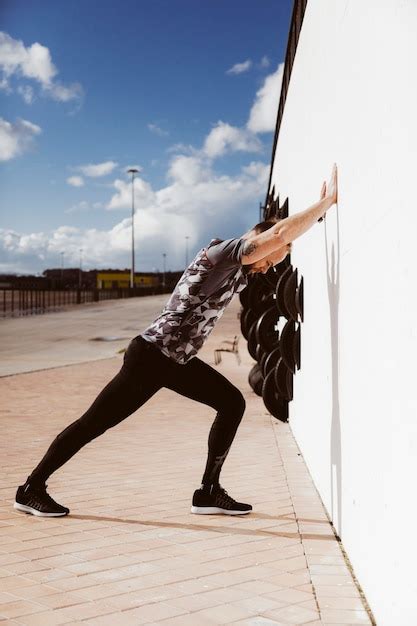 Free Photo Side View Of Young Sporty Man Doing Push Ups On Wall
