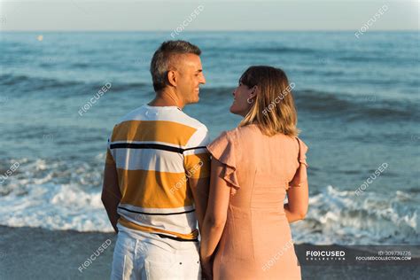 Adult Man And Woman Standing On Beach Near Waving Sea And Looking At Each Other — Heterosexual