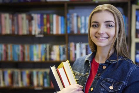 Portrait Of Young Woman Or Student With Books In Book Store Or Library