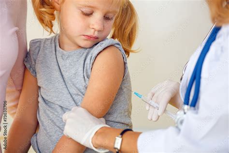 doctor vaccinating small redhead girl stock 写真 adobe stock