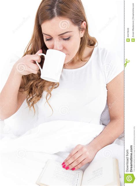 Young Woman Enjoying Reading And Drinking Coffee In Bed Stock Image