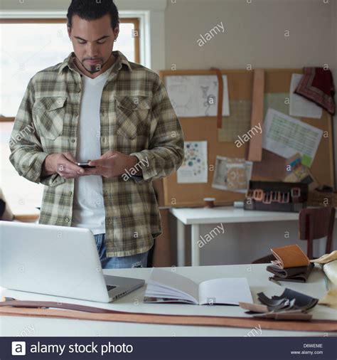 Mid Adult Man Reading Text Message With Laptop On Table Stock Photo Alamy