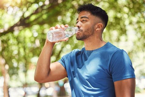 Young Mixed Race Athletic Man Drinking Water And Staying Hydrated While