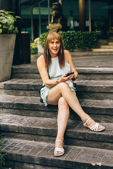 trans woman sitting and checking her phone by stocksy contributor jayme burrows stocksy