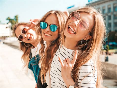 トレンディな夏服の3人の若い美しい笑顔流行に敏感な女の子の肖像画。路上でポーズをとってセクシーな屈託のない女性。サングラスで楽しんでいる
