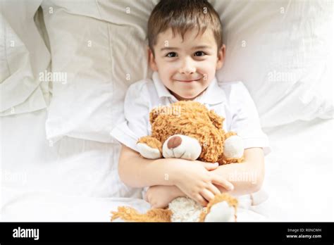 A Child Lying In Bed With A Plush Teddy Bear Stock Photo Alamy