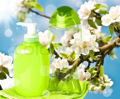 Liquid soap, sponge and towels in a wicker basket on a light background. Plastic bottle with liquid soap on nature background ...