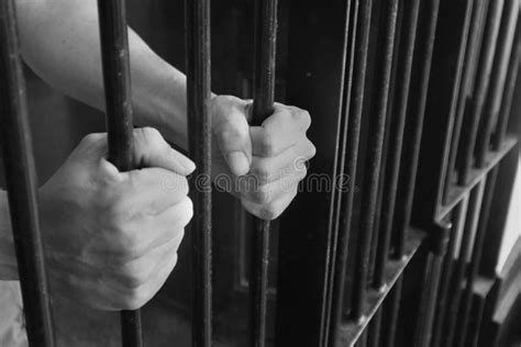 Prison Cell Barshand Of The Prisoner Holding Steel Lattice Jail Bars