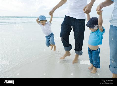 Familia Juntos Saltando En El Agua En La Playa Fotografías E Imágenes