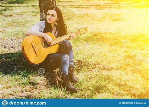 Beautiful Woman Playing An Acoustic Guitar Outdoor Stock