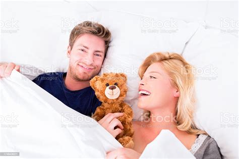 Foto De Jovem Casal Na Cama Com Cuddling Urso De Pelúcia E Mais Fotos