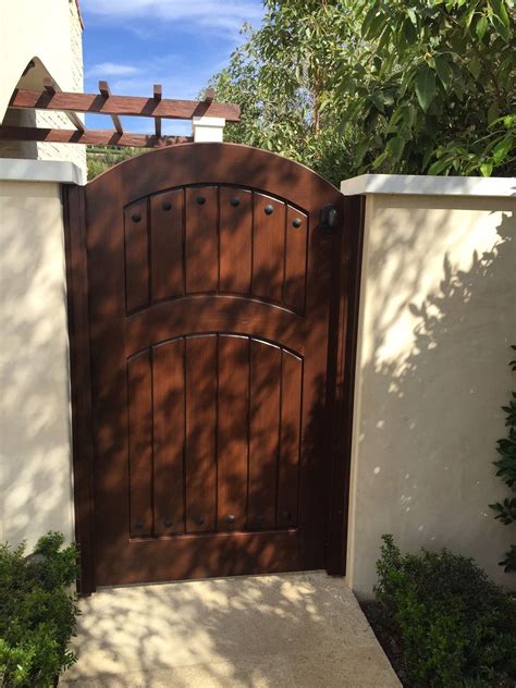Custom Wood Gate By Garden Passages With Arched Crossbar And Decorative