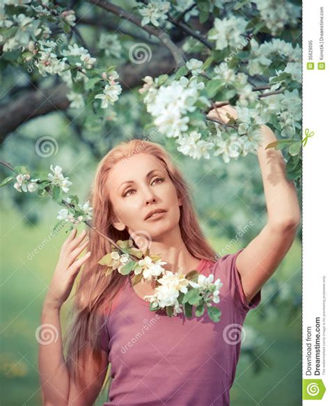 Young Attractive Woman Standing Near The Blossoming Apple Treewith A Retro Effect Stock Image