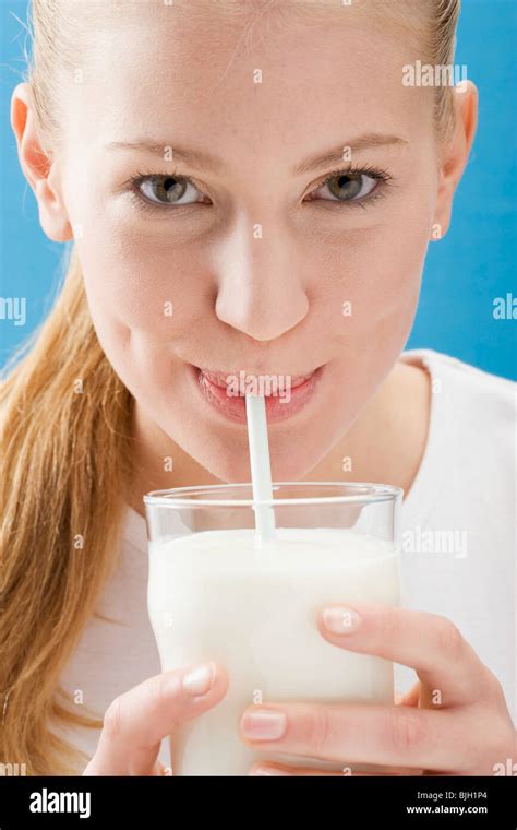 Young Woman Drinking Milk Through A Straw Stock Photo Alamy