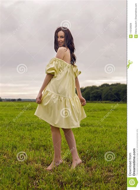 Woman In Yellow Dress Stands In A Field Stock Image Image Of