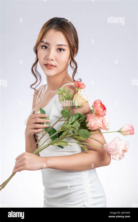 gorgeous female model with flawless fair skin and perfect makeup holding flowers bouquet woman