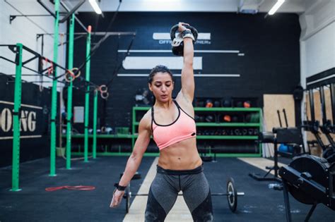 Premium Photo Young Woman Training Swinging Kettlebell Indoor In A