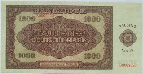 При зміні кута нахилу банкноти спостерігається кінетичний ефект — зміна напрямку руху фонового зображення. 1000 Deutsche Mark - German Democratic Republic - Numista