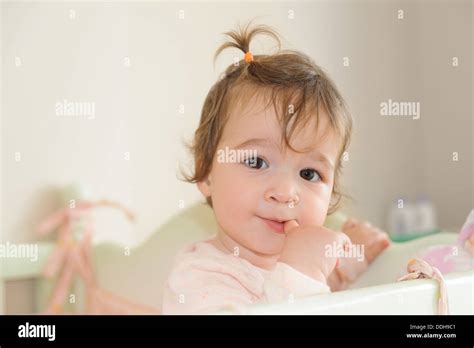 Cute Baby Girl Biting Her Forefinger In Bed Stock Photo Alamy