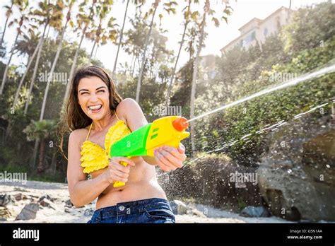 Caucasian Couple Playing With Squirt Guns On Beach Stock Photo Alamy