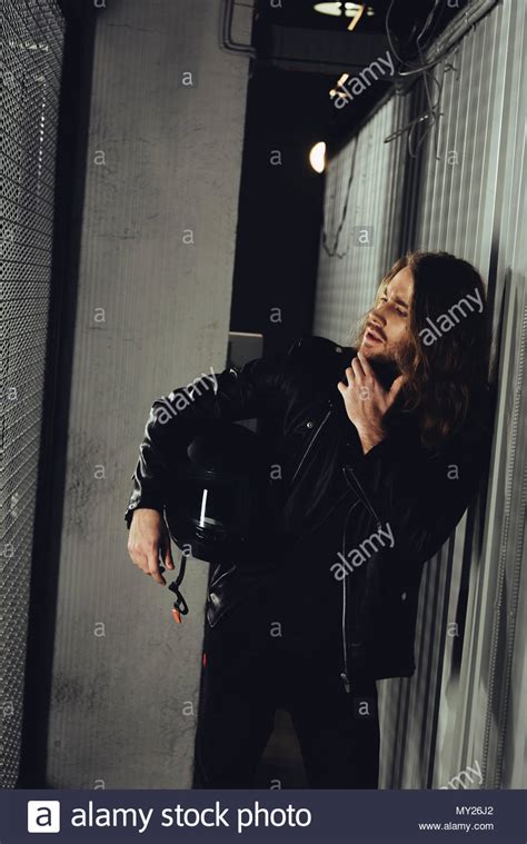 Stylish Bearded Man In Leather Jacket Holding Helmet And Looking Away Stock Photo Alamy