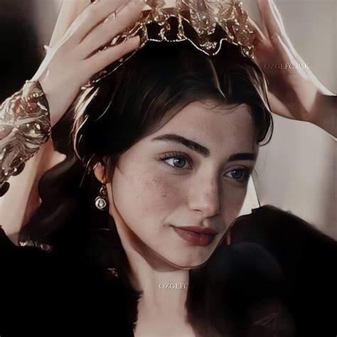 A Close Up Of A Person Wearing A Tiara And Holding Her Hair In The Air