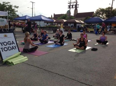 A Group Of People Sitting On Yoga Mats In A Parking Lot