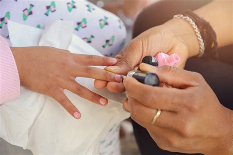 Woman Applying Nail Polish Doing Manicure To A Little Girl Fun